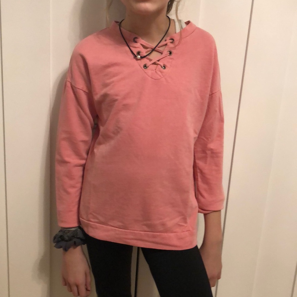 a pink long sleeve shirt with a crossed ties